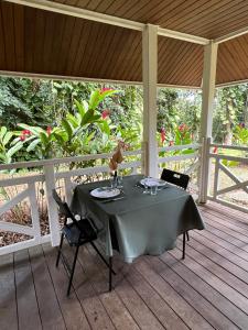 a table and chairs on a wooden deck at Bungalow Terra - Sarramea in Sarraméa
