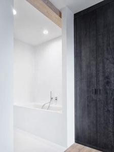 baño con puerta negra y lavamanos en Luxury Penthouse, Prime Location en Praga