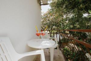 Hotel Vila Tina في تروغير: طاولة بيضاء صغيرة مع اثنين من المشروبات على شرفة