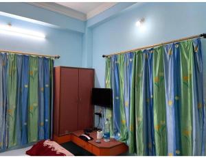sypialnia z zielonymi i niebieskimi zasłonami oraz łóżkiem w obiekcie Galaxy Inn, Agartala w mieście Agartala