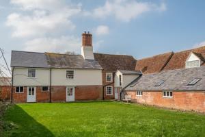 an old house with a grass yard in front of it at River House in Kersey