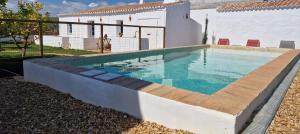a swimming pool in front of a house at Milagres de Santa Rita in Vila Nova De Cacela