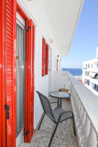 a table and chair on a balcony with the ocean at kleris apartment 3 in Tinos Town