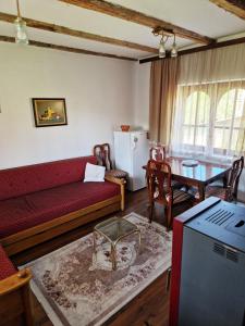 a living room with a red couch and a table at Domacinska kuca in Bajina Bašta +12 photos