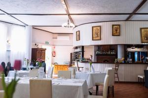 a dining room with white tables and chairs at Sosnowe Zacisze Barszczewo in Choroszcz