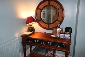 a table with a lamp and a mirror on it at The Hillcroft - Boutique, Unique in Torquay