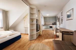 a living room with a bed and a desk in a room at Hummerklippen Apartments in Helgoland