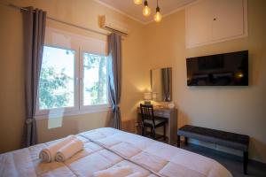 a bedroom with a bed and a desk and a window at Socratous Apartments in Mytilene