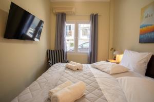 a bedroom with a white bed with towels on it at Two Bedroom Apartment, Mytilene Lesvos in Mytilini