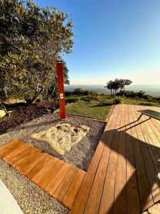 a wooden walkway with a red pole in a yard at Fantastic villa with panoramic coastal & sea views in Estói