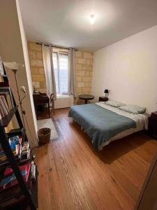 1 dormitorio con 1 cama y suelo de madera en Grand appartement en rdc avec jardin, en Burdeos