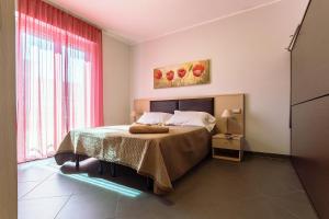 una camera da letto con un grande letto con tende rosse di Appartamenti Linda a San Bartolomeo al Mare