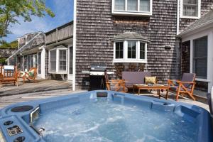 a hot tub on a patio next to a house at Walk to Water Hot Tub & Game Room in Eastham