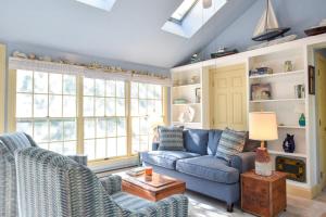 a living room with a blue couch and chairs at Walk to Water Hot Tub & Game Room in Eastham
