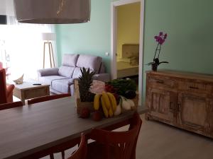una sala de estar con una mesa con frutas y verduras. en Mandala apARTments, en Calafell