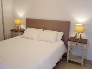 カラフェルにあるMandala apARTmentsのベッドルーム1室(白いベッド1台、テーブルにランプ2つ付)