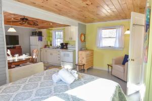 a bedroom with a bed and a kitchen at Bright Cottage Close to Bayside Beaches in Eastham