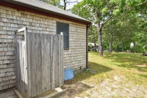 a house with a wooden fence next to a yard at Spacious Home w Finished Game Room in Eastham