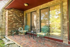 a porch with chairs and a cat sitting on it at Spacious Home w Finished Game Room in Eastham