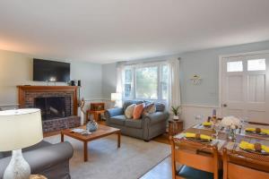 a living room with a couch and a fireplace at 14482 - Exceptional Home with Backyard Oasis Close to Great Pond Bay and Ocean Beaches in Eastham