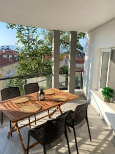 een houten tafel en stoelen op een balkon bij 9 House in Fethiye