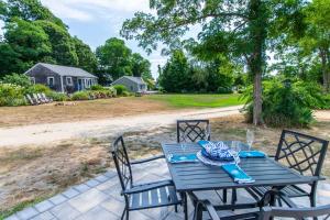 einen blauen Tisch mit Stühlen auf einer Terrasse in der Unterkunft Newly Renovated Cottage on Town Cove in Eastham