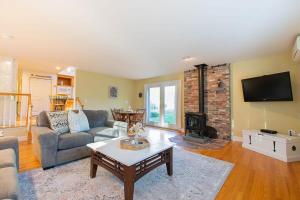 a living room with a couch and a fireplace at 4-5 Min to Mill Pond or Nauset Beach in Orleans