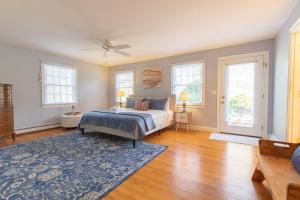 a bedroom with a bed and a blue rug at 4-5 Min to Mill Pond or Nauset Beach in Orleans