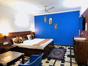 新德里的住宿－Golden Bed and Breakfast- High Quality Rooms in South Ex-1 D Block，一间卧室设有蓝色的墙壁、一张床和一张桌子