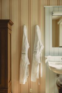 a bathroom with white towels hanging on the wall at Brøndums Hotel in Skagen
