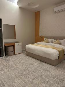 a bedroom with a large bed and a mirror at فندق هوم ليا للشقق الفندقيه in Riyadh