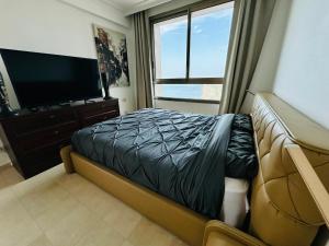 a bedroom with a bed and a flat screen tv at Luxurious Beach apartment in Haifa