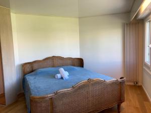 a teddy bear sitting on a bed in a bedroom at Maison à 2 pas de Genève in Ambilly