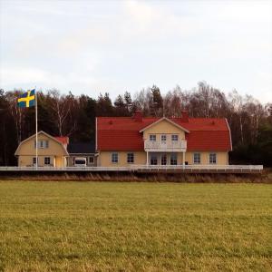 una casa con una bandera en medio de un campo en Gula huset en Gotemburgo