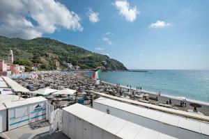 a beach with a bunch of chairs and the ocean at Bilocale via Rimembranze 6 in Levanto