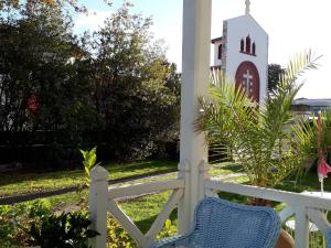 une clôture blanche avec une chaise sur une terrasse couverte avec une église dans l'établissement Villa Glen-Tara, à Lanton