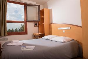 sypialnia z dużym łóżkiem i oknem w obiekcie Villages Clubs du Soleil - LES KARELLIS w mieście Montricher-Albanne