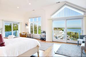 a bedroom with a bed and a view of the ocean at 2 Min Walk to Private Beach & Boat Launch in Orleans