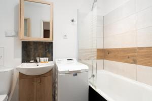 La salle de bains est pourvue d'un lavabo, de toilettes et d'une baignoire. dans l'établissement Cozy Studio Retro in Poznan by Renters, à Poznań