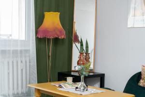 een tafel met een lamp en een vaas erop bij Cozy Studio Retro in Poznan by Renters in Poznań