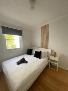 a bedroom with a large white bed with a window at 3 Bedroom House Ideal for Family - Ultimo in Sydney