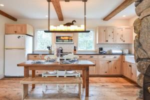 a kitchen with wooden cabinets and a wooden table at Central A C Private Path to Nauset Beach in Orleans