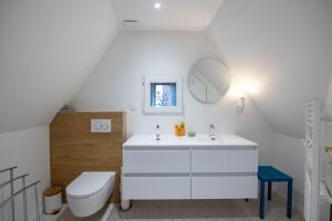 a white bathroom with a toilet and a sink at Les Gîtes Coeur de Vigne in Riquewihr +34 photos