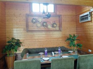 Ri Shat Orchid Resort في شيلونغ: غرفة طعام خشبية مع طاولة وكراسي