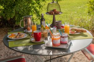 uma mesa coberta com pratos de alimentos e bebidas em HOTEL et APPARTEMENTS DOMAINE DES CLOS - Teritoria em Beaucaire