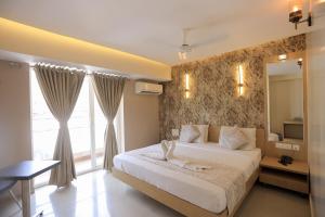 een slaapkamer met een groot bed en een spiegel bij Hotel Shoolin Grand in Mangalore