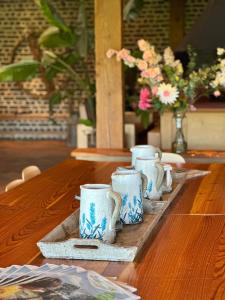einen Tisch mit vier blauen und weißen Tassen auf einem Tablett in der Unterkunft Landhuis Bovenste Bos in Epen