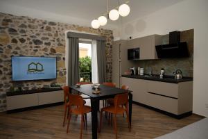 a kitchen and dining room with a table and chairs at INCAO HOLIDAY LA STRUMMULA HOUSE in Cefalù