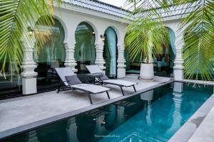 Ban Mut Dok KhaoにあるMarococco Private Pool Villaのプール、椅子2脚、ヤシの木があるリゾートです。