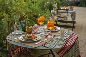 stół z talerzami jedzenia i napojów w obiekcie HOTEL et APPARTEMENTS DOMAINE DES CLOS - Teritoria w mieście Beaucaire